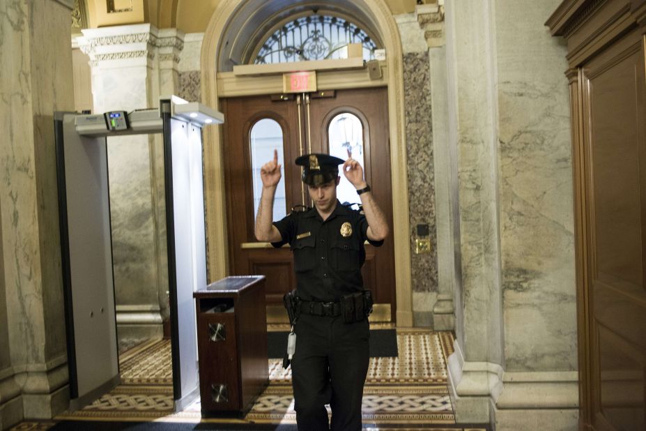 A Capitol Police officer directs people away from a door on Capitol Hill.