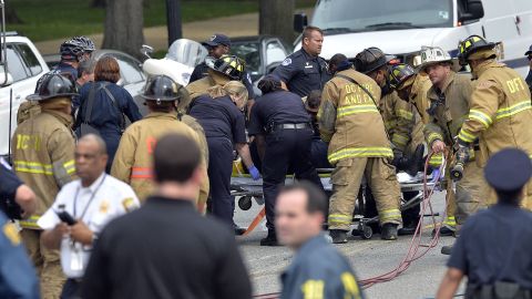 First responders put a police officer on a stretcher after pulling him out of a wrecked cruiser.