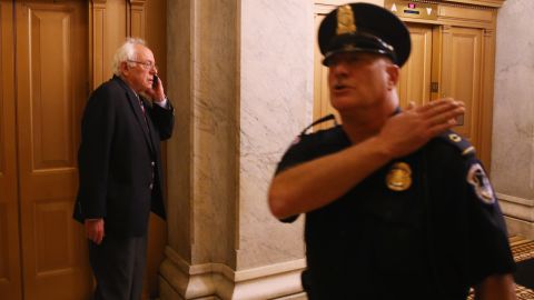 Sen. Bernie Sanders speaks on the phone at the Capitol.