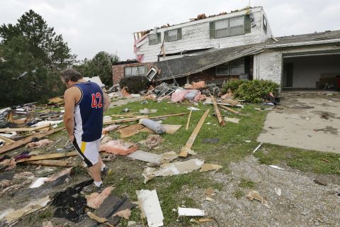 Travis Randall walks through the debris-strewn yard of his parent's home in Hickman, Nebraska, on October 4 after it was struck by a tornado.