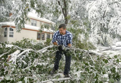 Thomas Leighton clears branches and tree limbs from the street in Casper, Wyoming, on October 4. A major storm dumped heavy, wet snow over Wyoming, bringing down trees and power lines along the way.