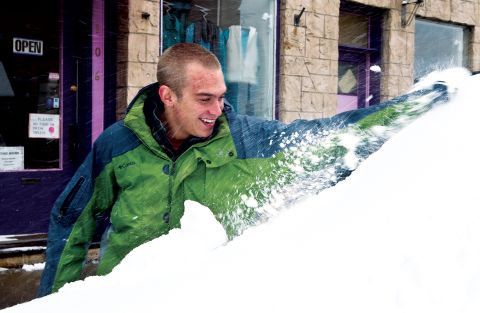 Sam Cornia brushes snow off of the windshield of his car on October 4 in Laramie, Wyoming.