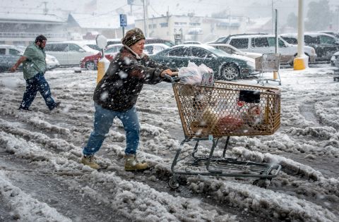 Brenda Nolting, of Rapid City, South Dakota, rolls her cart to her car after stocking up on necessities on October 4.