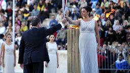 Actress Ino Menegaki (R), playing a high priestess, hands the Olympic flame to the president of the Hellenic Olympic Committee, Spyros Kapralos, on October 5, 2013 at the Panathenaic stadium in Athens during a handover ceremony of the Olympic flame for the the Sochi 2014 Olympic Winter Games which begin on February 7. AFP PHOTO / LOUISA GOULIAMAKI (Photo credit should read LOUISA GOULIAMAKI/AFP/Getty Images)
