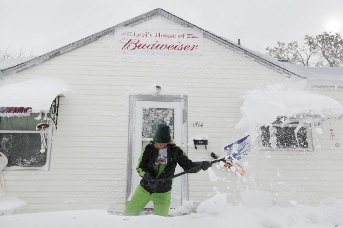 Lori Mehlberg shovels snow to clear a pathway to her home in Rapid City, South Dakota, on October 5. Half the approximately 60,000 residents of Rapid City were without power as of Friday evening, according to Jerry Reichert, a battalion chief with the Rapid City Fire Department.
