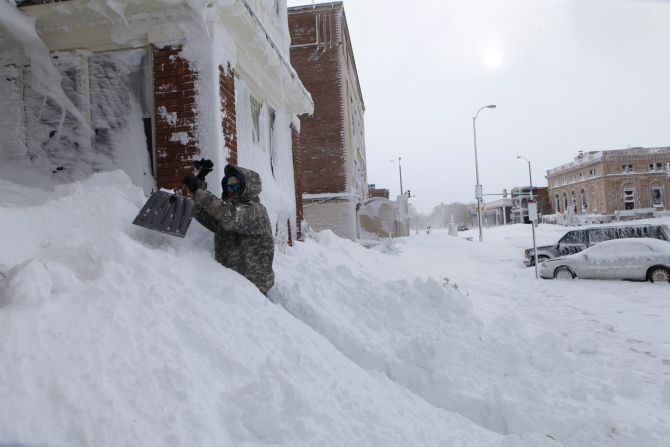 Chad Hoffman clears snow from the entrance to his apartment building in Rapid City, South Dakota, on October 5. 