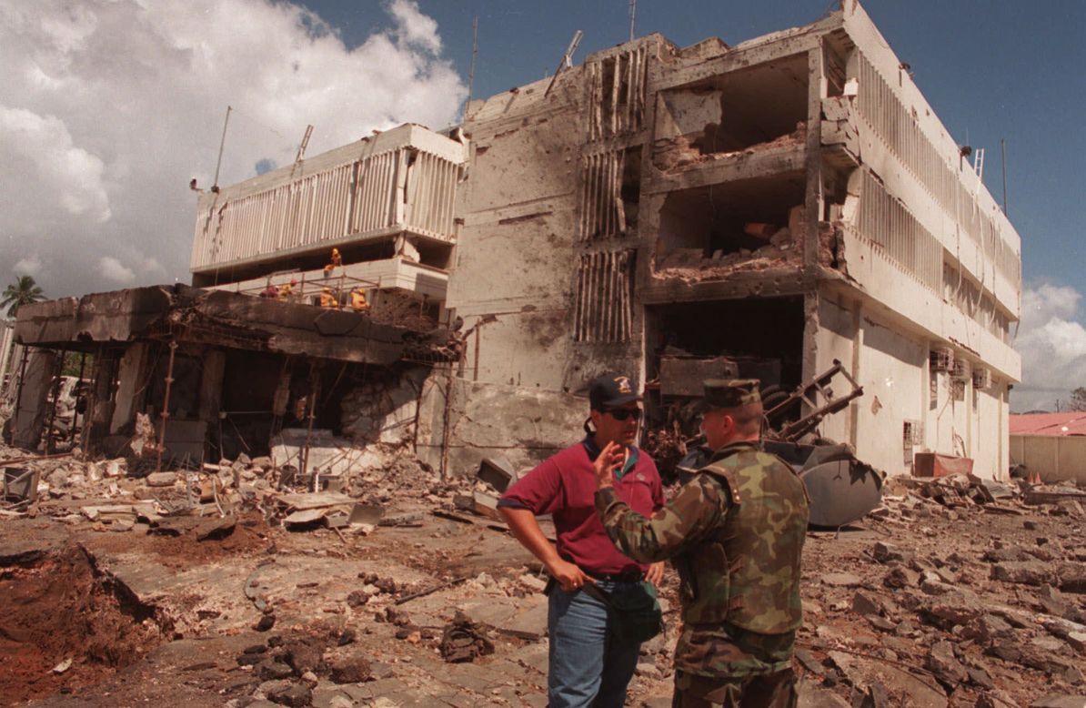 A U.S. Marine talks with an FBI investigator in front of the bomb-damaged U.S. Embassy in Dar es Salaam, Tanzania, on August 15, 1998.