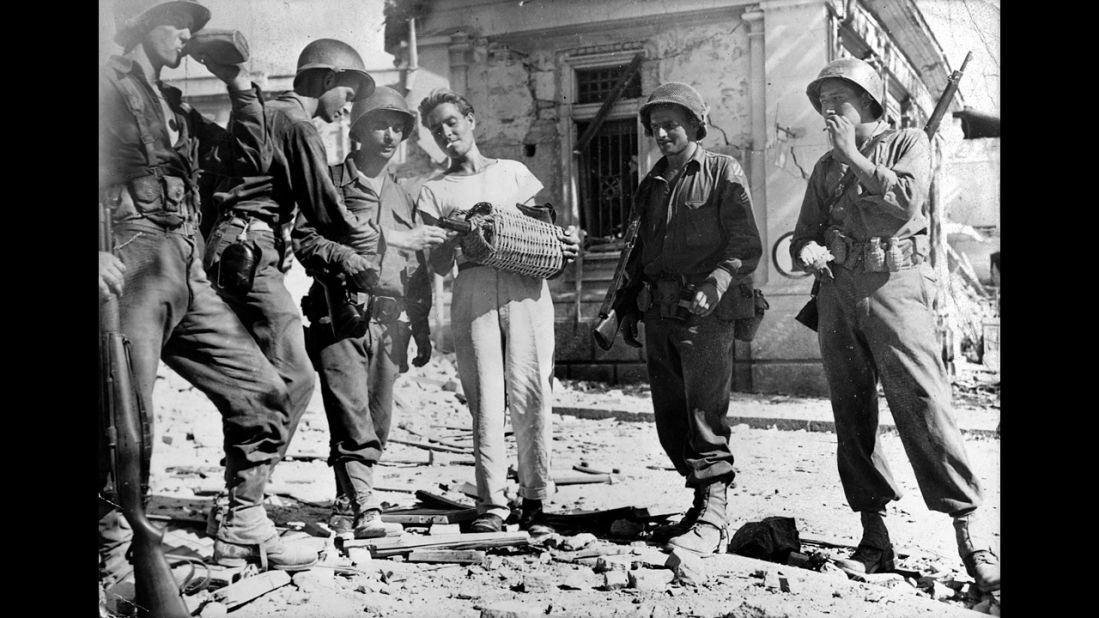 Persevere and you'll find many Sicilians transform from standoffish to almost overwhelmingly hospitable -- here a man offers wine to U.S. troops during World War II. 