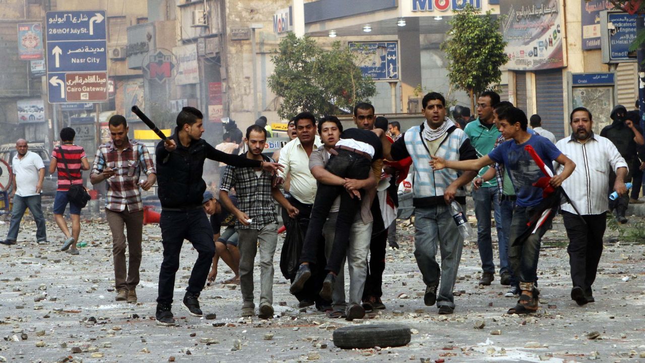 People carry a man near Ramses Square in Cairo.