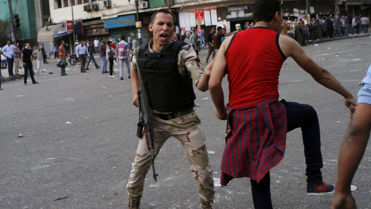 An Egyptian army officer tries to prevent a supporter of Defense Minister Gen. Abdel-Fattah al-Sisi from clashing with Morsy backers on October 6 in Cairo.
