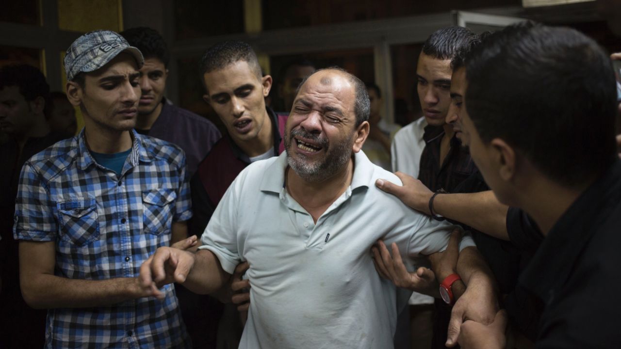 Bystanders try to comfort a man as he grieves for a relative slain during clashes October 6 in Cairo.