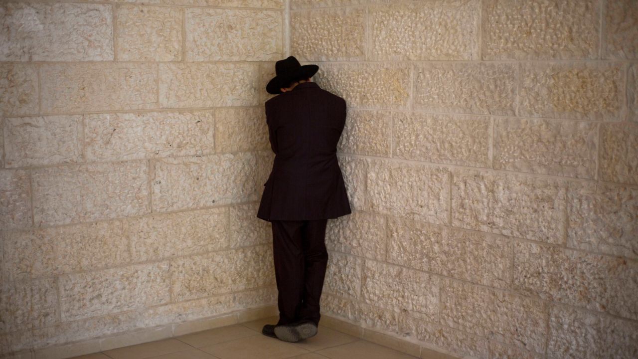 A man weeps outside Yosef's home in Jerusalem after hearing about the rabbi's death.