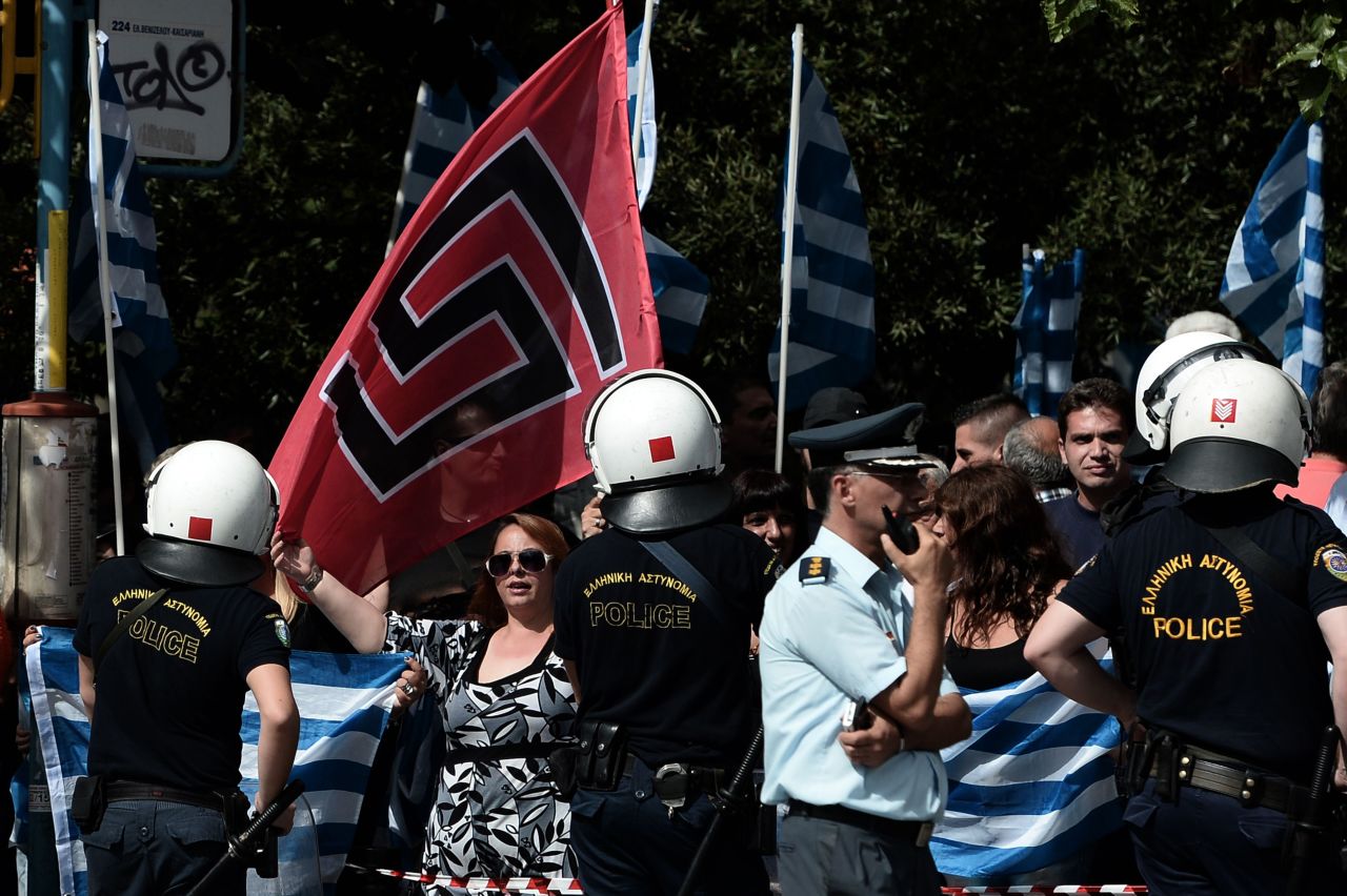 Supporters of Golden Dawn wave the party's flag along with Greek flags during a protest outside a court in Athens on October 2, 2013.