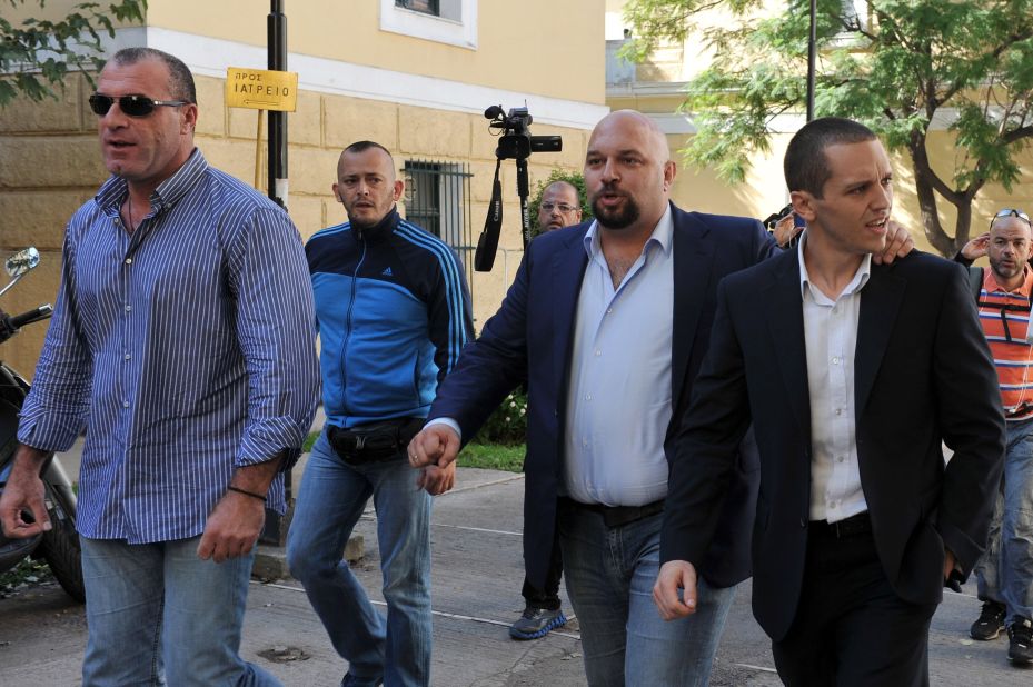 Extreme-right Golden Dawn party lawmakers Nikos Michos (L), Ilias Panagiotaros (C) and Ilias Kasidiaris leave a courthouse after being released on October 2, 2013 in Athens, Greece. 