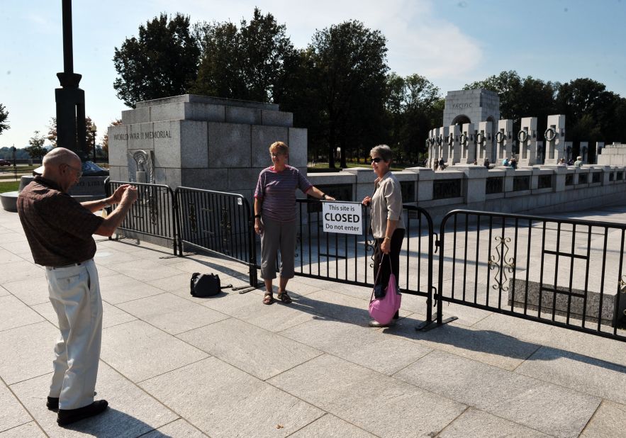 Tourists take photos at a barricade blocking access to the World War II Memorial in Washington on Sunday, October 6.