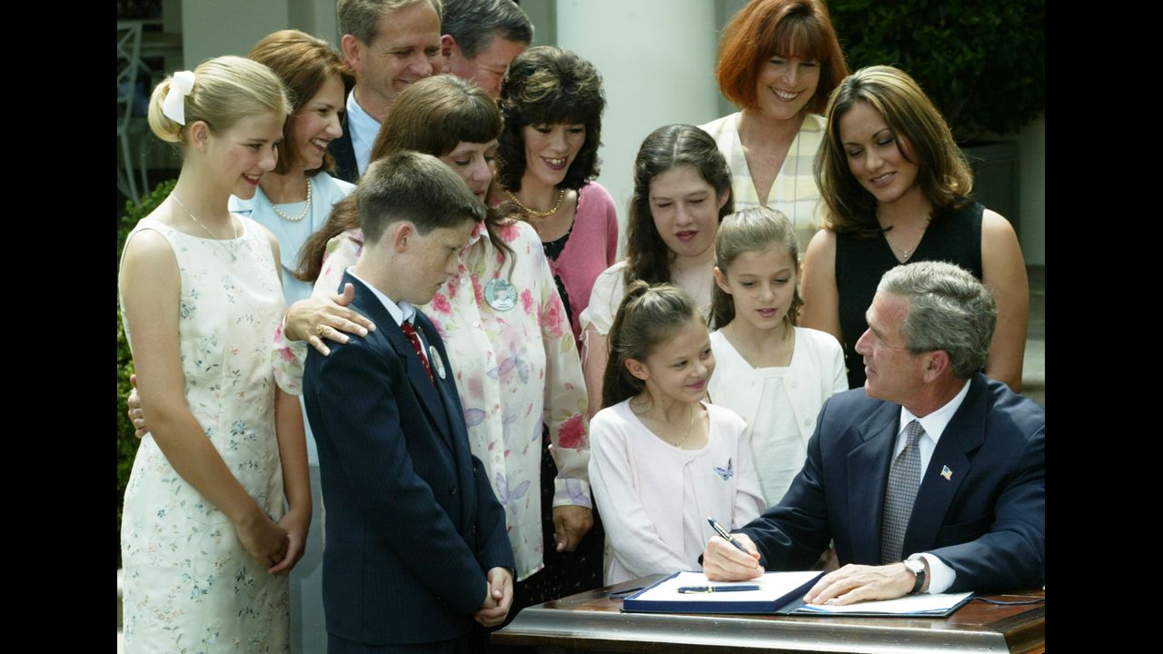 Smart stands with families of kidnapped victims as President George W. Bush signs the Amber Alert law at the White House in April 2003.
