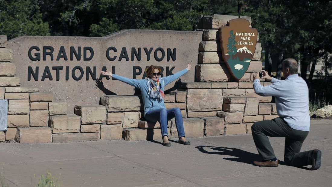 Austrian tourist Ryszard Skrzypek snaps a photo of his wife, Walendowska Malgorzata, close to the entrance to Grand Canyon National Park near Tusayan, Arizona, on Friday, October 4. Park officials have written citations for people trying to sneak into the park.