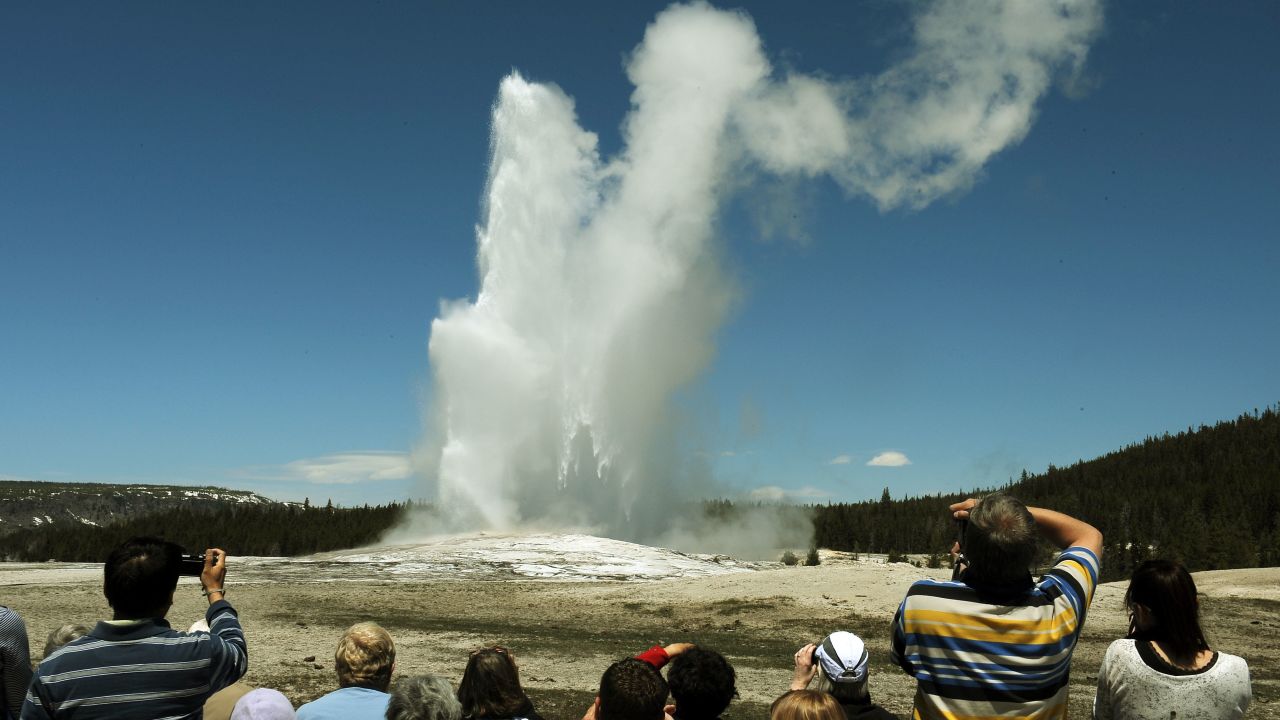 Tourists watch the Old Faithful geyser in the Yellowstone National Park in Wyoming in June 2011. One tourist told a Massachusetts newspaper that National Park Service guards treated members of her tour group brusquely and told them not to "recreate" while taking pictures of bison.