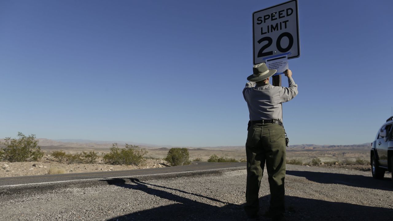 Park maintenance worker Donna Curry tapes up a sign on October 1 notifying visitors the picnic facility in Lake Mead National Recreation Area near Boulder City, Nevada, is closed. A Nevada couple told CNN affiliate <a href="http://www.ktnv.com/news/local/226557661.html" target="_blank" target="_blank">KTNV-TV</a> they were kicked out of their cabin, which is on federal land.