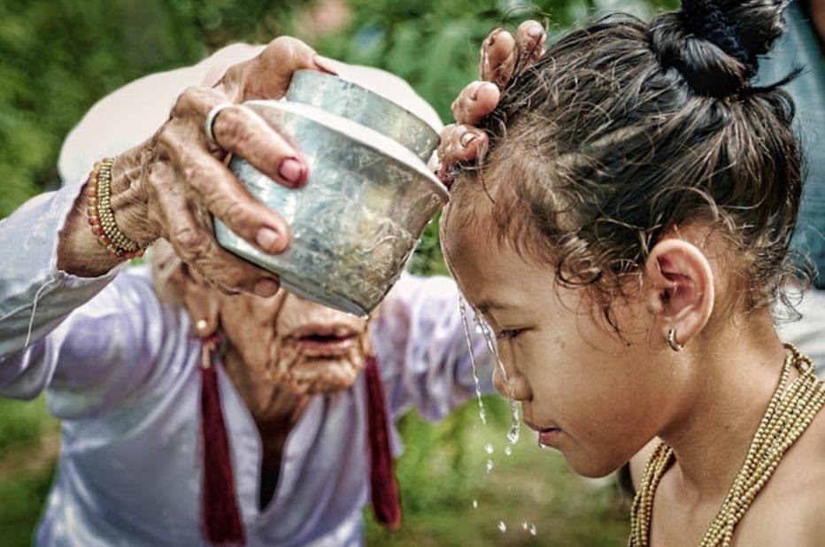 In preparation for the Karoh (maturity) ceremony, a girl is ritually purified by having water poured over her head by the most respected old woman in a Muslim community in Ninh Thuan, central Vietnam. The ceremony is considered one of the most important ritual events of their lives and the girls will then be recognized as an adult in the community.
