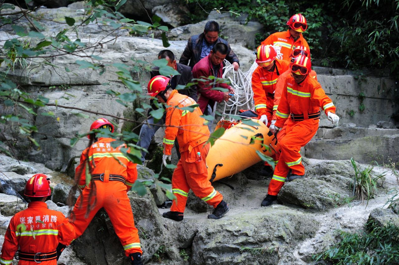 Rescuers carry Kovats' body down the mountainside on October 9. Nearly 200 firefighters and police officers were involved in the search operation, according to Xinhua.