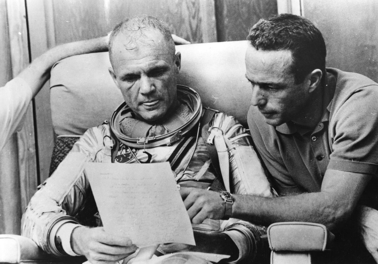 Glenn, left, checks over notes with back-up pilot Carpenter after a simulated flight before the Mercury-Atlas 6 mission at Cape Canaveral in 1962.