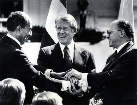 President Jimmy Carter, center, Egyptian President Anwar Sadat, left, and Israeli Prime Minister Menachem Begin join hands after signing the Camp David Accords. Sadat and Begin won the Nobel Peace Prize in 1978. 