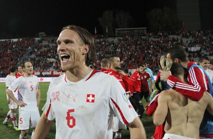 Switzerland's Michael Lang scored the crucial second goal in their 2-1 win in Albania to clinch qualification for football's global showcase.