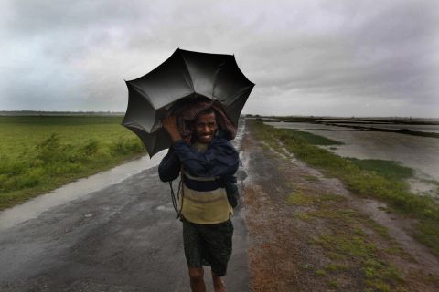 An Indian villager braves the strong winds and rain as he walks to safety in the village of Podampeta on October 12. 