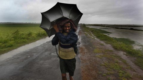 An Indian villager braves the strong winds and rain as he walks to safety in the village of Podampeta on October 12.