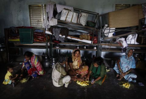 Evacuated villagers eat in a temporary cyclone shelter in the town of Chatrapur, India, on October 12.