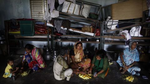 Evacuated villagers eat in a temporary cyclone shelter in the town of Chatrapur, India, on October 12.