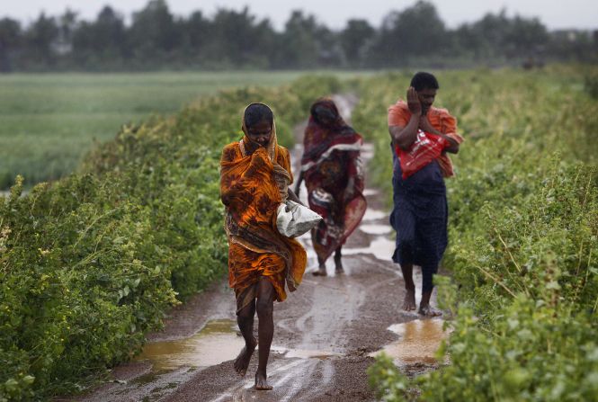 Villagers head for a cyclone center in the village of Podampeta, India, on October 12.