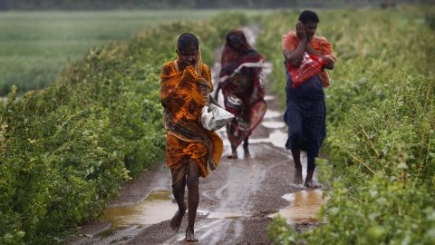 Villagers head for a cyclone center in the village of Podampeta, India, on October 12.