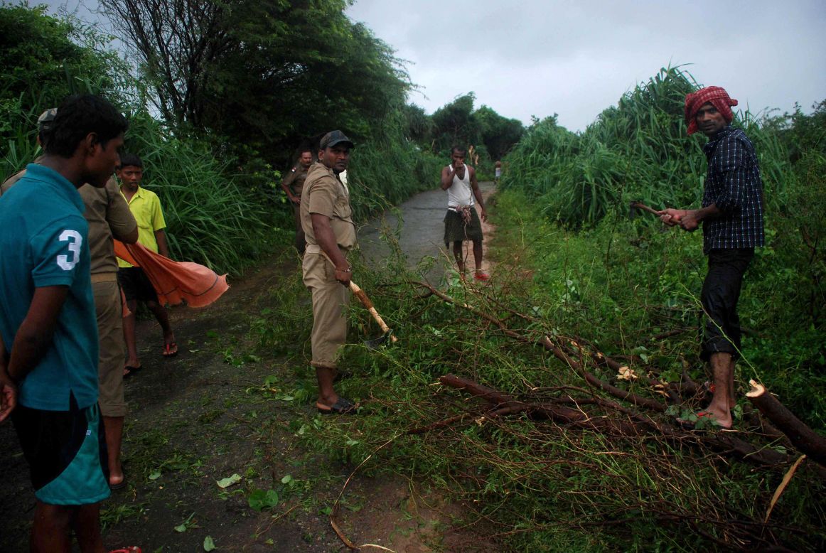 Volunteers clear branches off the road in the village of Badabandha on October 12.