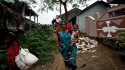 An Indian woman carries her child as they leave their home at Donkuru village, in the Srikakulam district on October 12, 2013.   Nearly half a million people have been evacuated from India's impoverished east coast ahead of a massive cyclone expected to make landfall on October 12  evening, disaster officials said.  AFP PHOTO/ MANAN VATSYAYANA        (Photo credit should read MANAN VATSYAYANA/AFP/Getty Images)