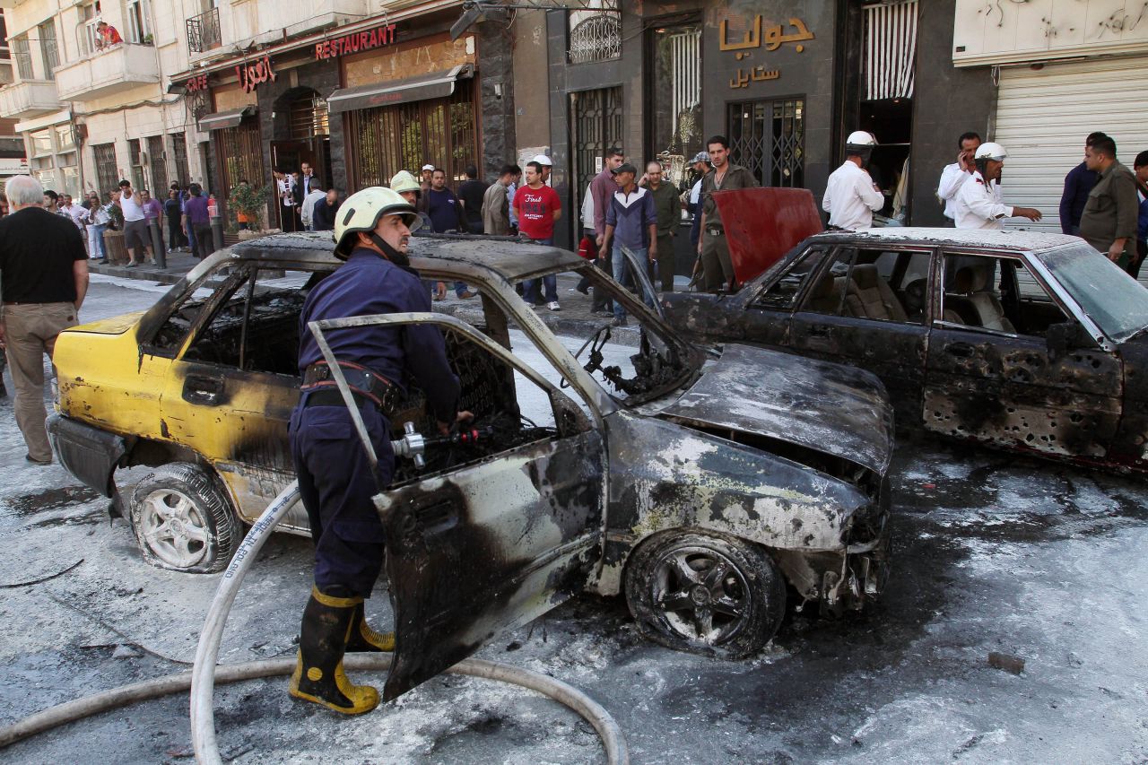 Firefighters extinguish a burning vehicle after two mortar rounds struck the Abu Roumaneh area in Damascus, Syria, on Saturday, October 12.