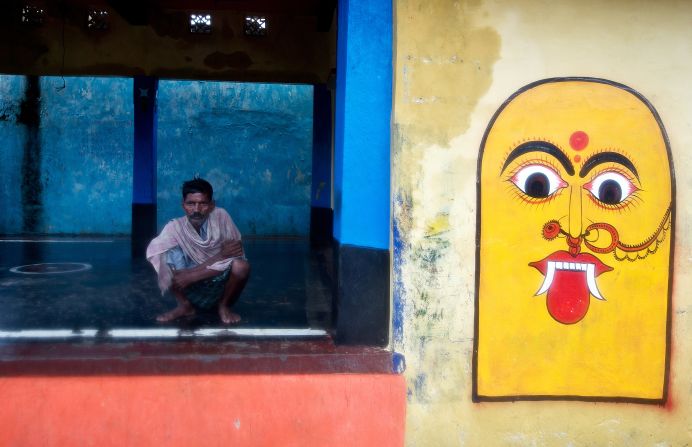 A villager sits in an empty courtyard as others evacuate the village of Donkuru on October 12.