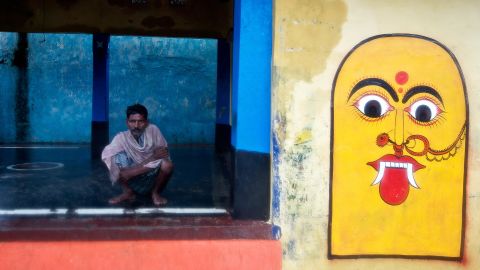 A villager sits in an empty courtyard as others evacuate the village of Donkuru on October 12.