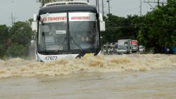Vehicles maneuver through flood waters on a road in the northern Philippines October 12, 2013.