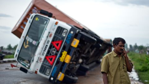 Indian truck driver Jairam Yadav speaks on his mobile phone after his truck carrying Toyotas was overturned by strong wind on the highway linking Andhra Pradesh and Odisha, India, on October 13.
