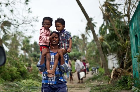 A man carries his children in Sonupur on October 13.