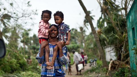 A man carries his children in Sonupur on October 13.
