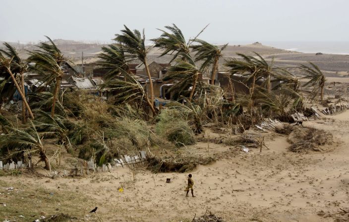 A woman returns to the village of Arjipalli on India's Bay of Bengal coast on October 13. 