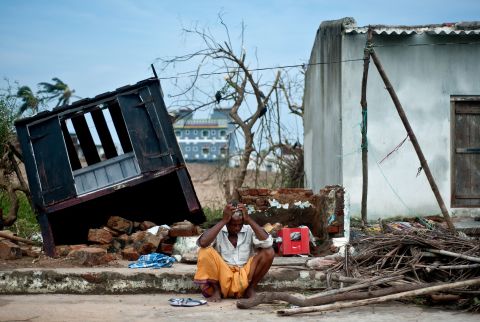Bhagwan, a coconut seller, sits in front of his destroyed shop in the town of Gopalpur on Sunday, October 13.