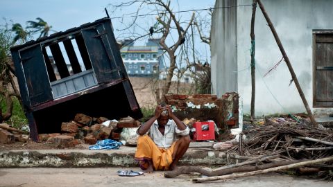 Bhagwan, a coconut seller, sits in front of his destroyed shop in the town of Gopalpur on Sunday, October 13.