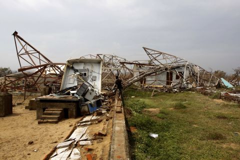 A man walks toward a damaged cellular phone tower in Berhampur on India's Bay of Bengal coast on October 13.