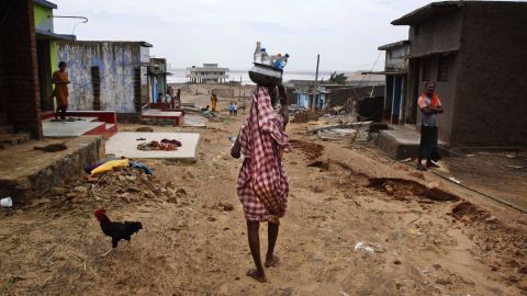 A villager carries drinking water in bottles as she arrives at the cyclone-hit village of Arjipalli on October 13.