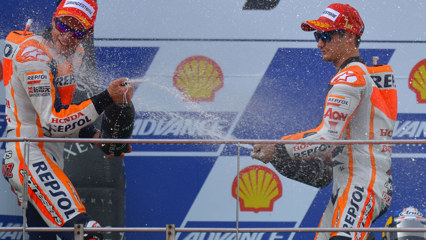 Dani Pedrosa sprays his Honda teammate and title leader Marc Marquez as he celebrates his Malaysian MotoGP win. 