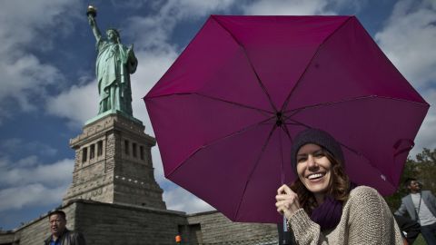 Tourists pose for pictures during a visit to the Statue of Liberty on Sunday in New York City. 